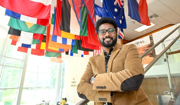 Man stands in front of flags