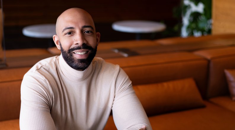 ODU alumnus Damien Geter sits at a table 