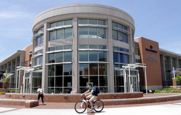 Student riding a bike in front of Broderick Dining Commons