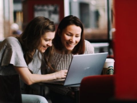 Two students viewing a laptop screen